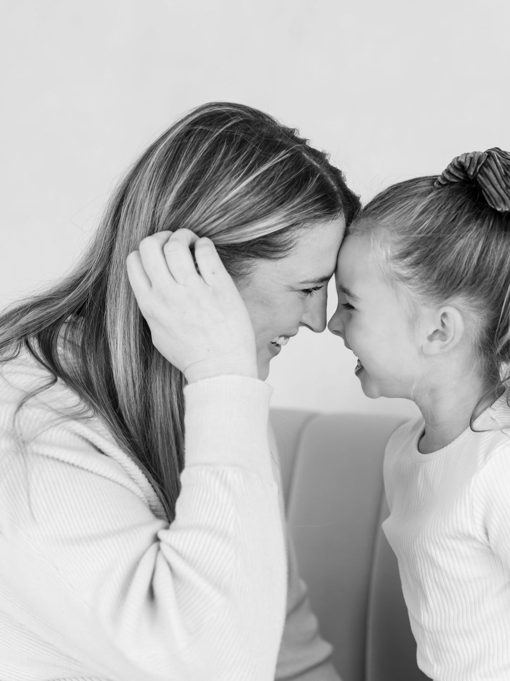 A series of black and white photos showing two people in white tops leaning in close to each other emotionally.