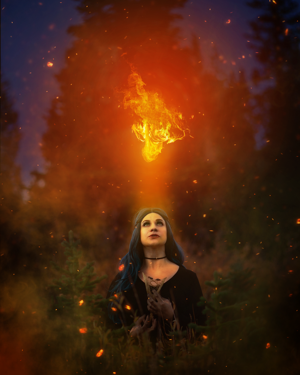Mystical fantasy portrait of a woman in dark clothing with magical fire effects above.