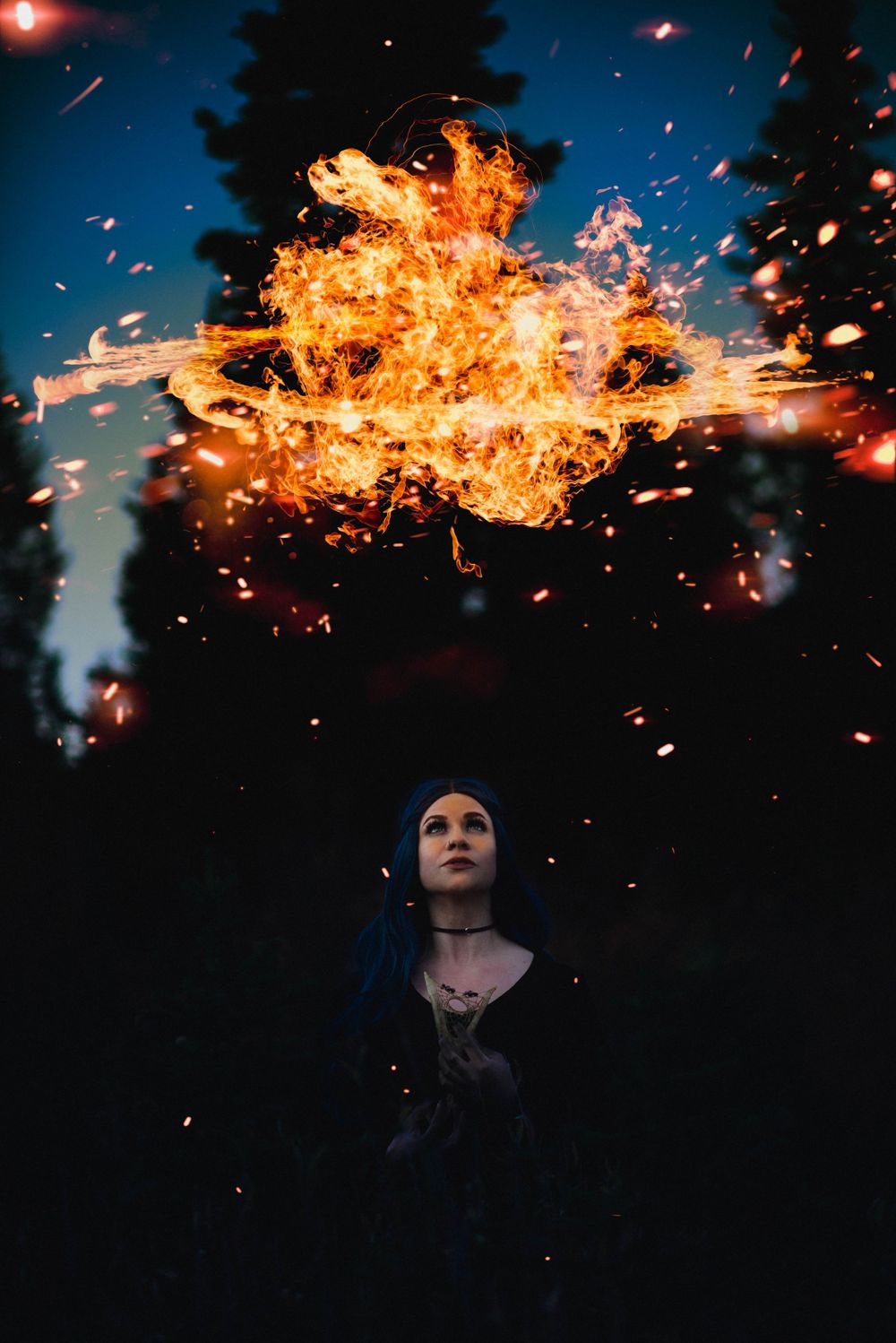 Dramatic portrait with large fire explosion effect against night sky.