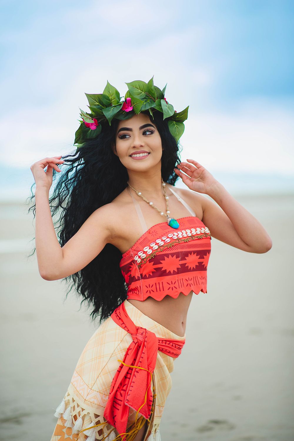 Tropical beach photoshoot featuring traditional Polynesian-inspired costume and flower crown.