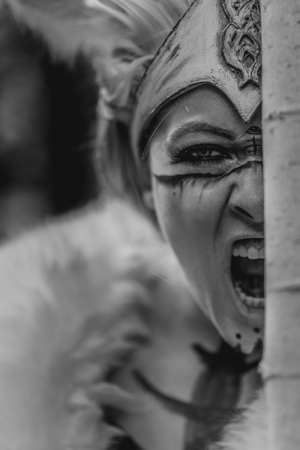 Dramatic black and white close-up of an ornate theatrical mask showing intense emotion.