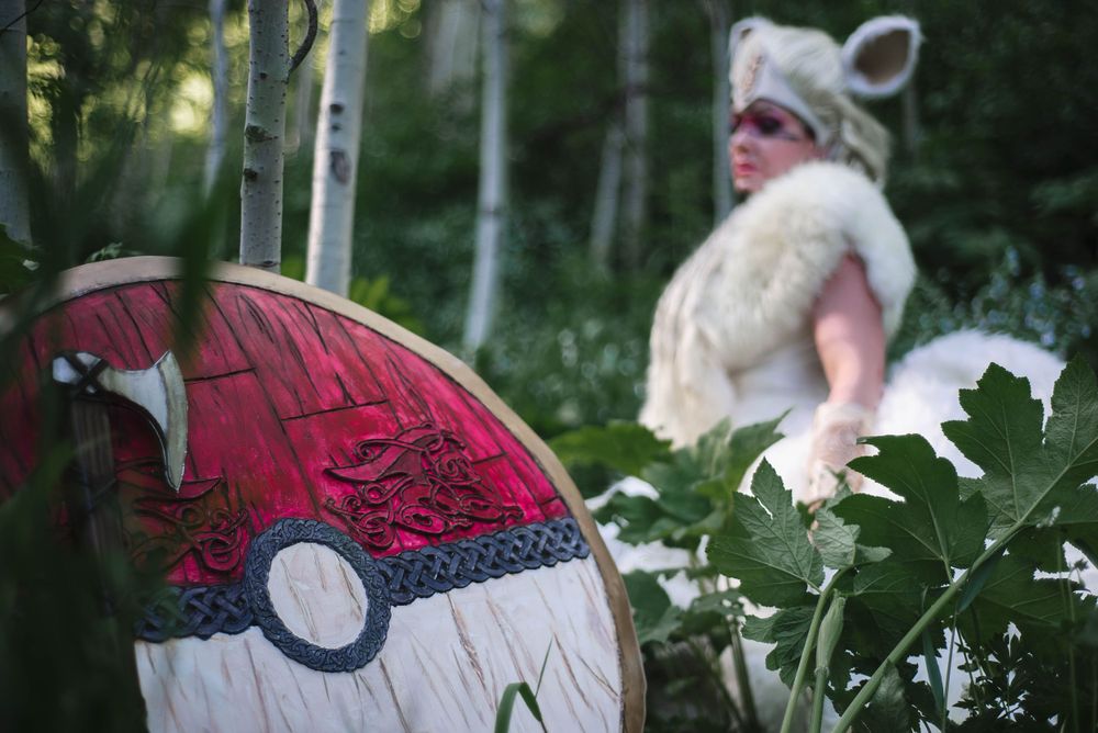 A Pokemon-themed red Pokeball prop visible in the foreground with a costumed figure in the background.