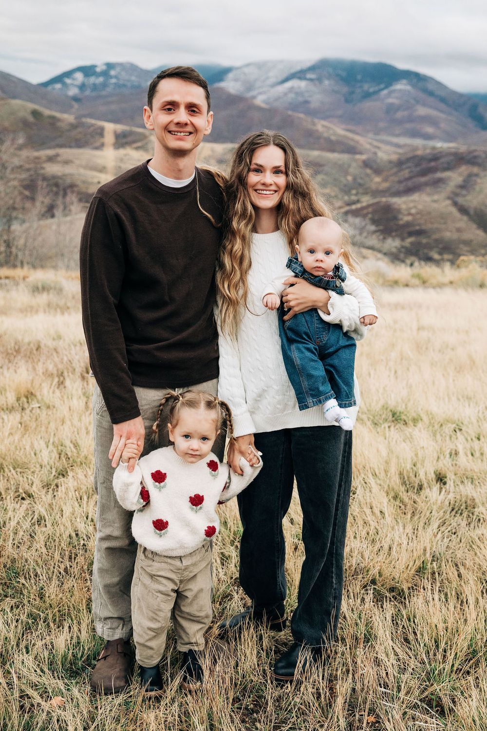 A family poses together in a grassy field with mountains in the background across multiple candid shots.