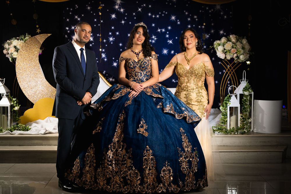 Wide shot of a formal event featuring an elaborate navy blue ball gown celebration.