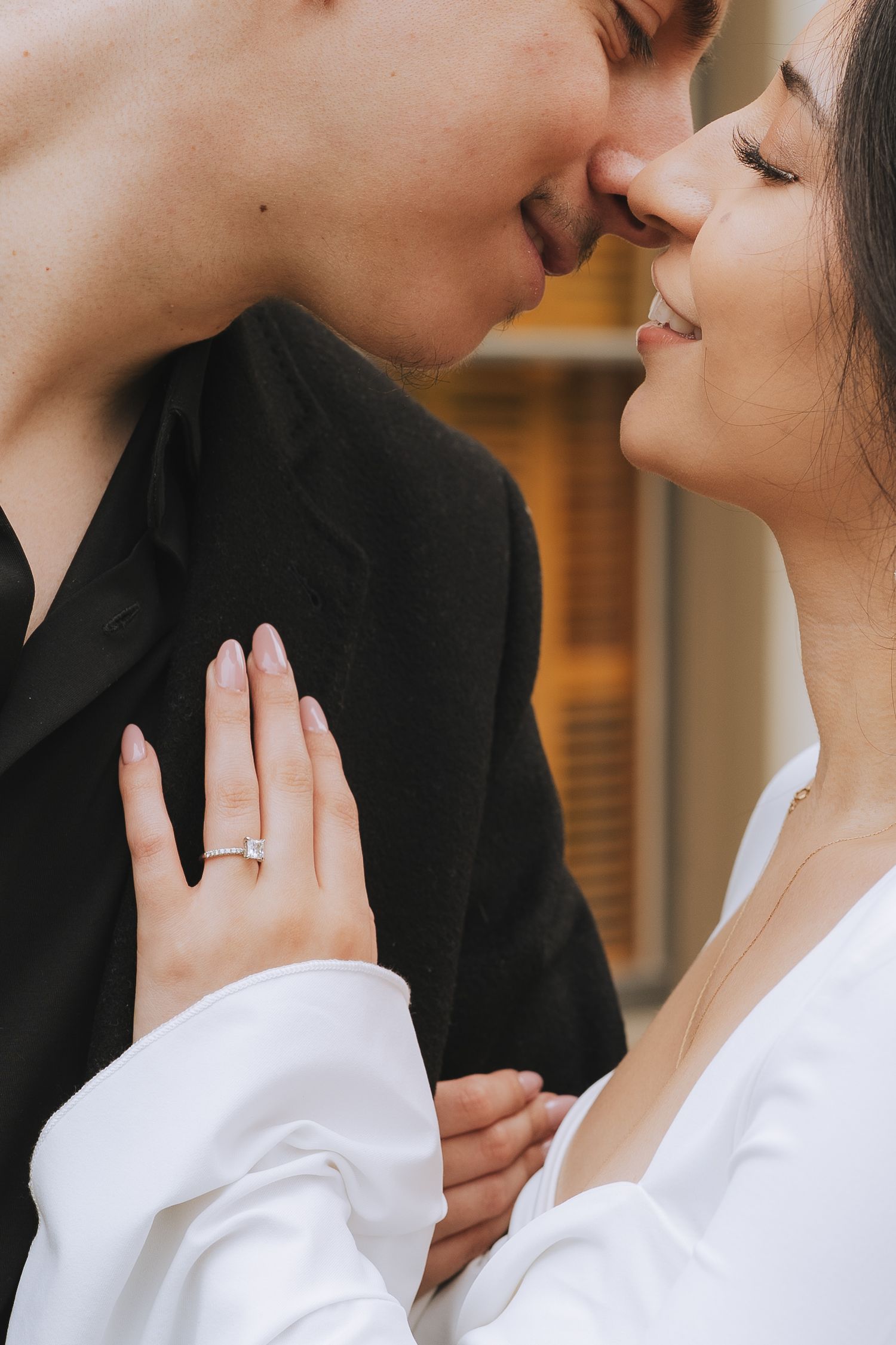 Intimate engagement photo series showing couple in white and black attire with ring detail.