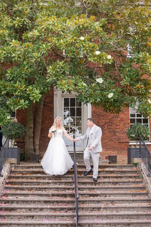 Sequence of couple descending brick steps with lush greenery overhead.