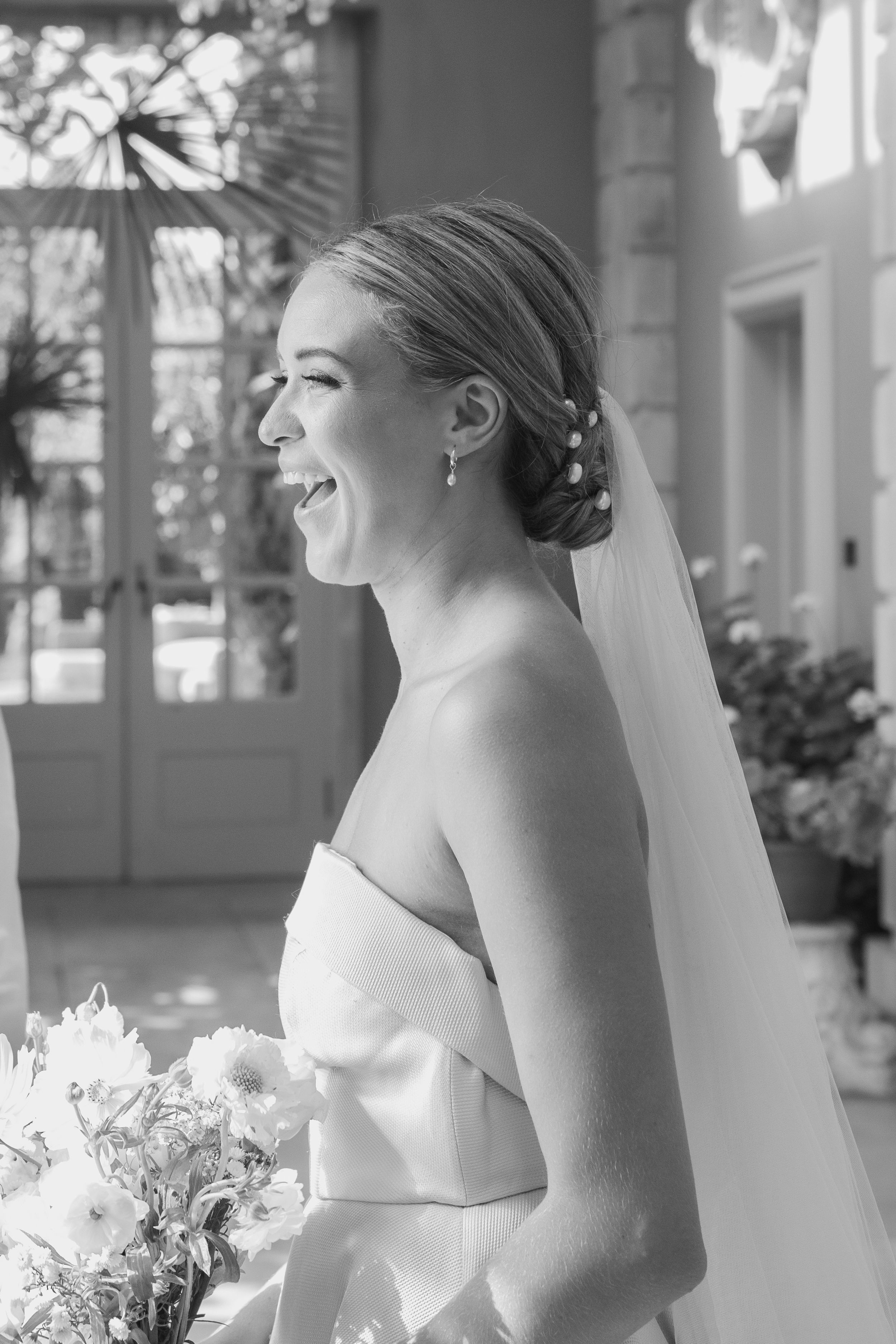 Candid bridal portraits showing joyful laughter on an elegant veranda.