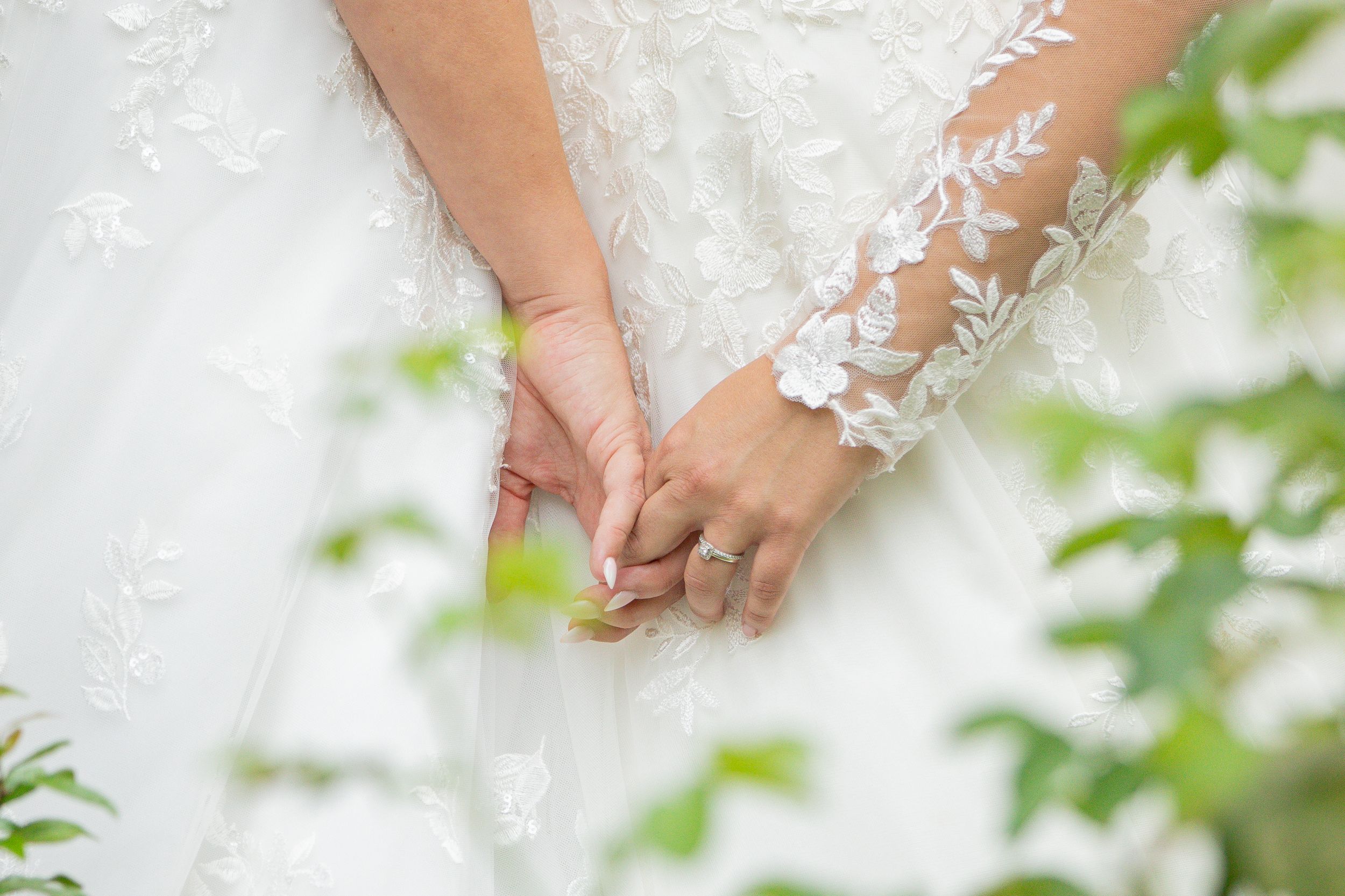 Close-up detail of delicate white lace sleeves on an elegant wedding dress.