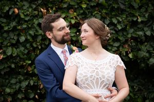 A romantic outdoor portrait against lush green foliage.