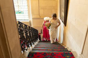 A church staircase with red carpet and black railings creates an elegant wedding backdrop.