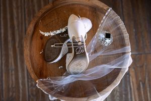 Wedding accessories artistically arranged on rustic wooden surface.