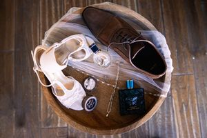 Wedding dress and accessories artistically arranged against rustic wooden background.