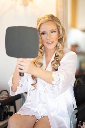 Getting ready scene with white lace robe and hair styling preparations.