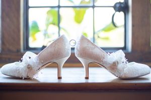 Delicate white meringue cookies arranged on a rustic wooden surface near a window.