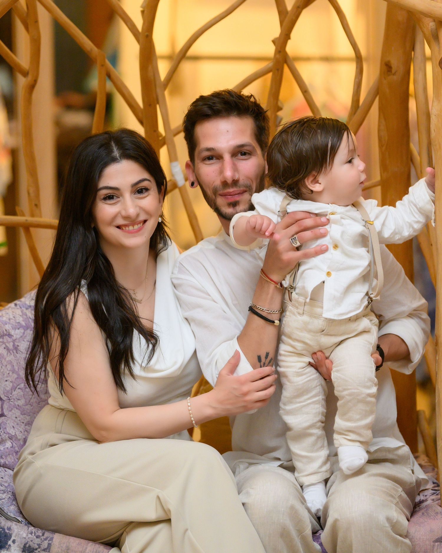 A family portrait in formal attire posing together in an elegantly decorated interior setting.