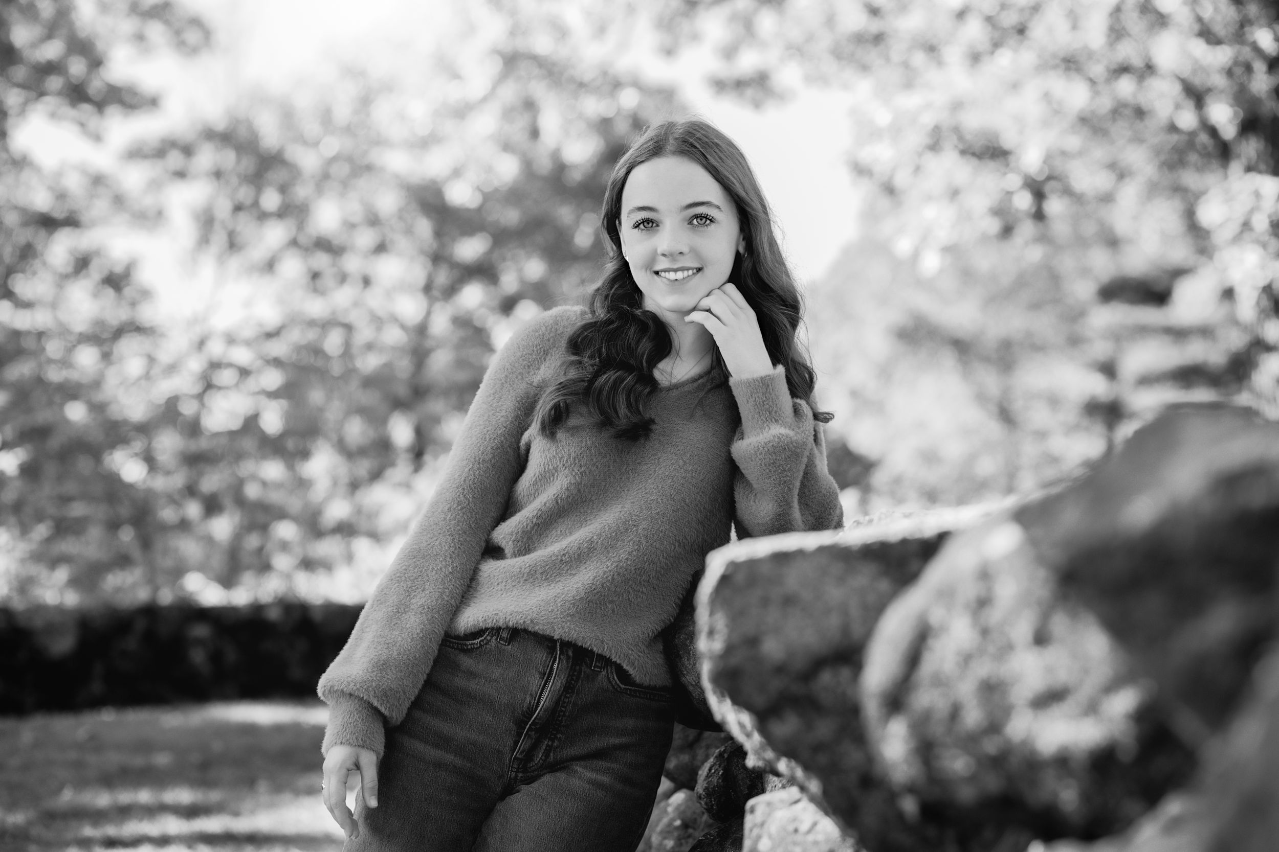 A black and white candid portrait of a woman outdoors.