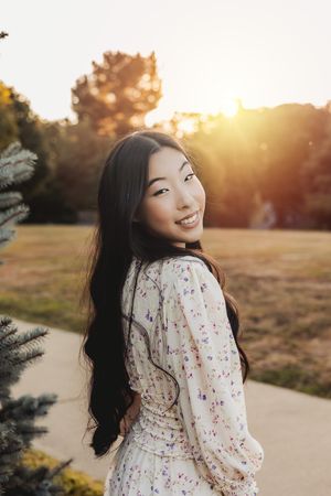 A sunset photoshoot featuring a white floral dress against a golden hour backdrop.