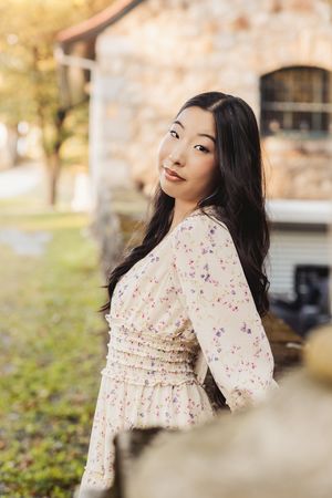 A floral dress photoshoot in an urban setting with soft lighting and blurred background.