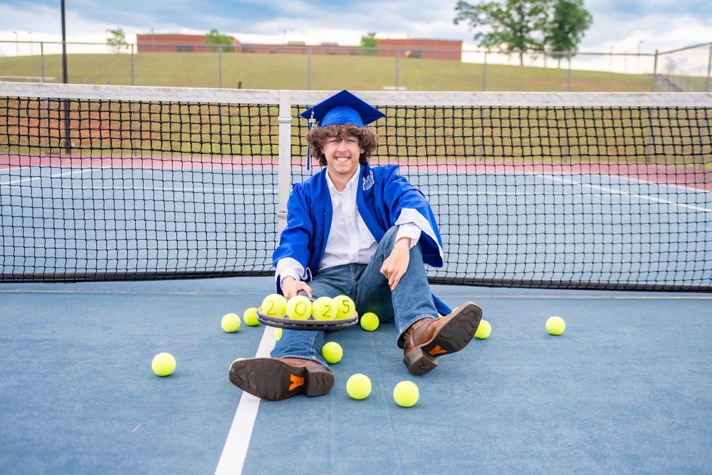Tennis balls scattered on a blue court surface with a tennis net visible in the background.