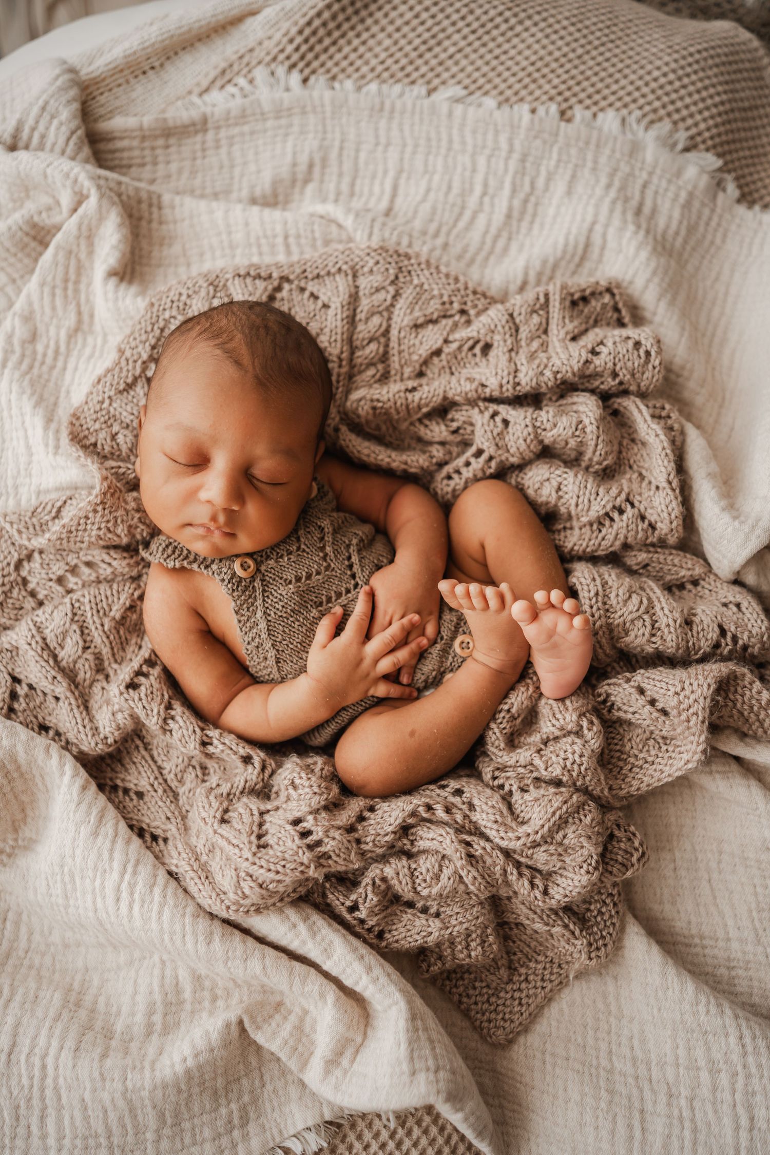 Sleeping baby boy snuggled peacefully in blankets during his portrait session with an in-home newborn photographer from Portland in Dorset