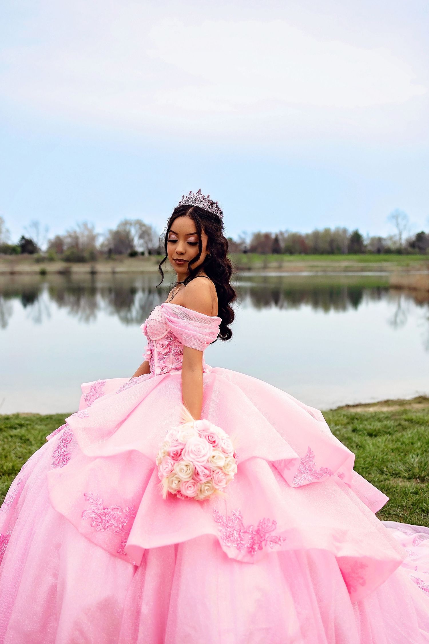 A romantic pink ballgown with intricate details creates an enchanting lakeside scene.