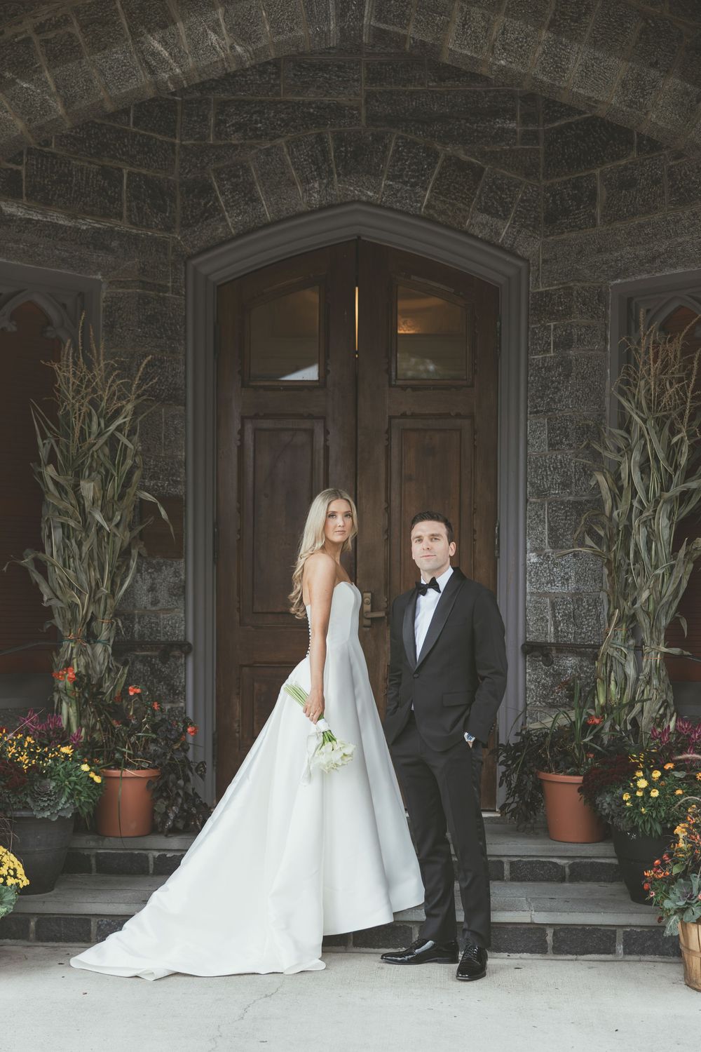 A series of wedding photos showing a couple posing in front of a stone church entrance with potted plants and flowers.