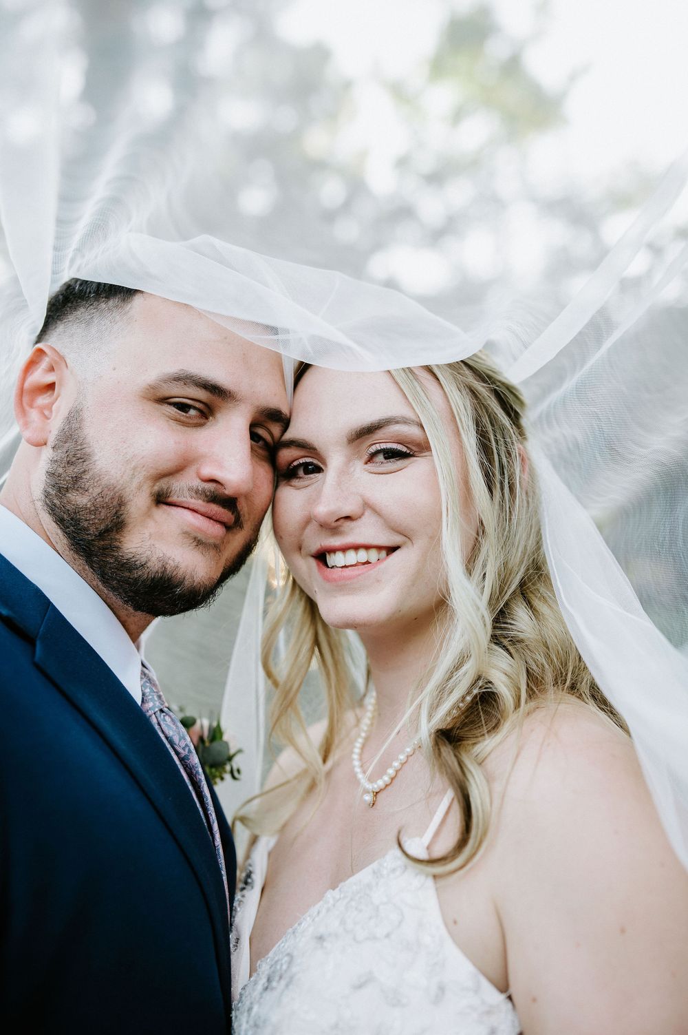 A romantic wedding photo series showing tender moments between a couple in white against a soft blurred background.