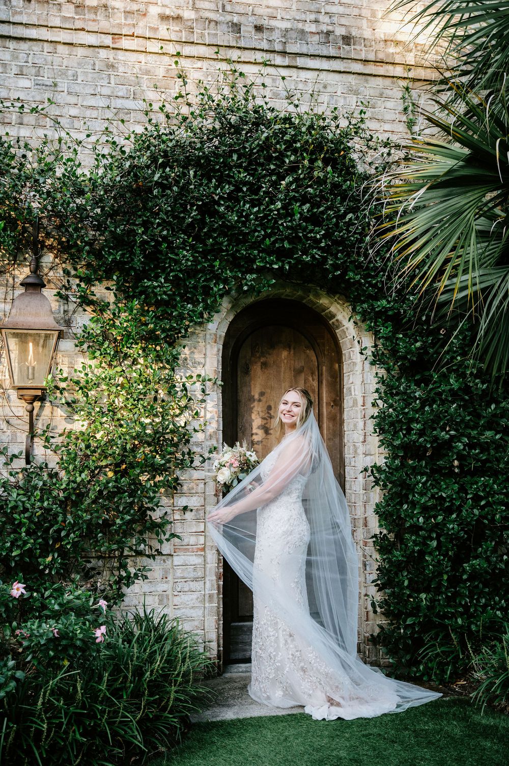 Elegant bridal portraits in a lush garden setting with stone archways and climbing vines creating a romantic backdrop.