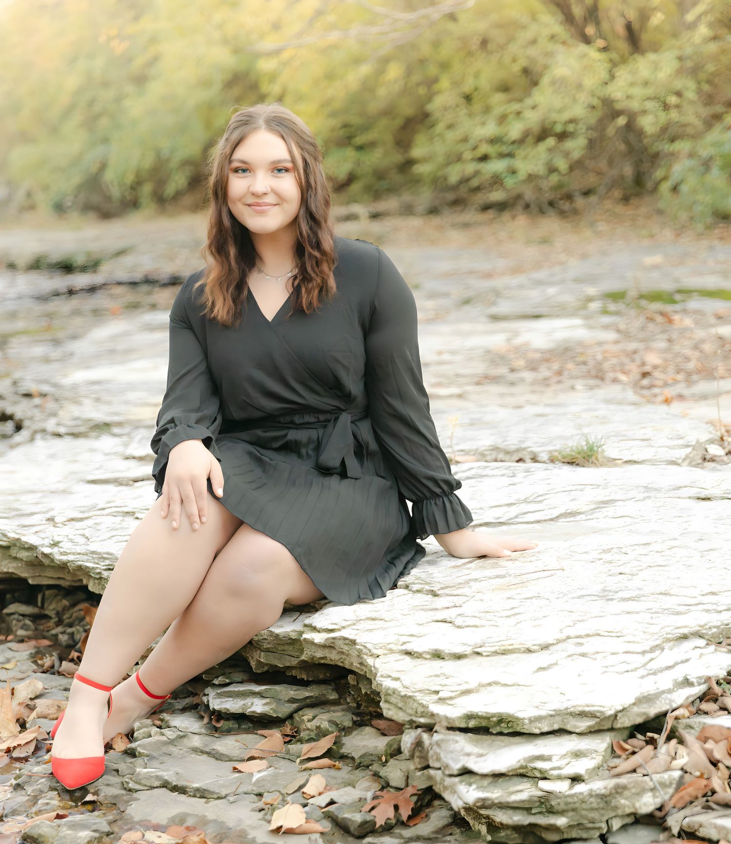 A person in a red top and jeans sits casually on a concrete surface in an artistic photo series.