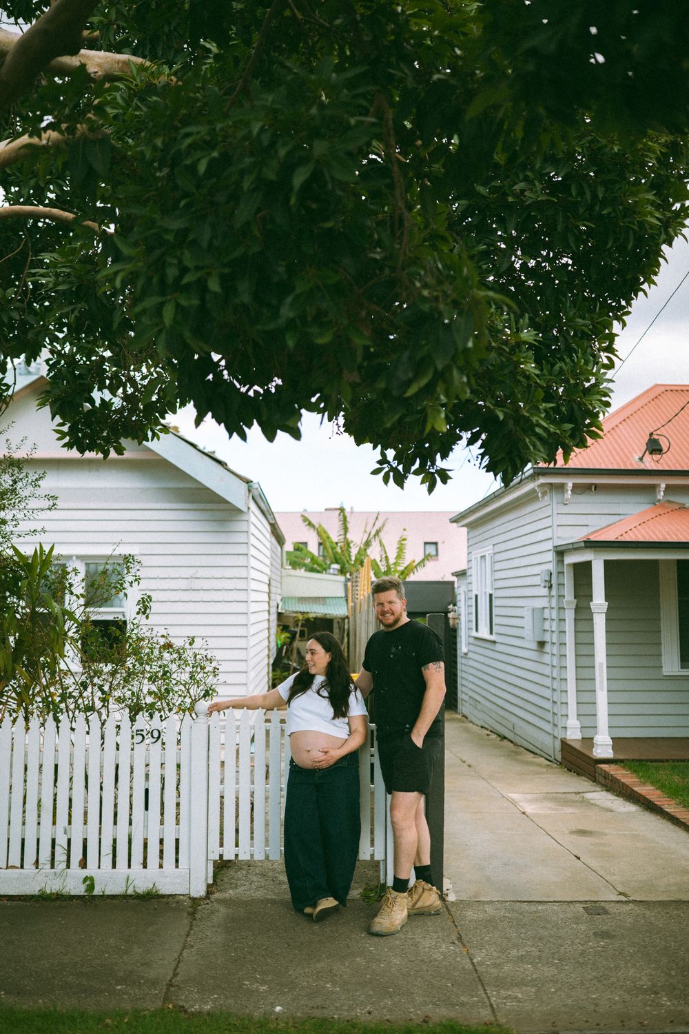 A series of photos showing people walking along a white picket fence outside suburban houses.