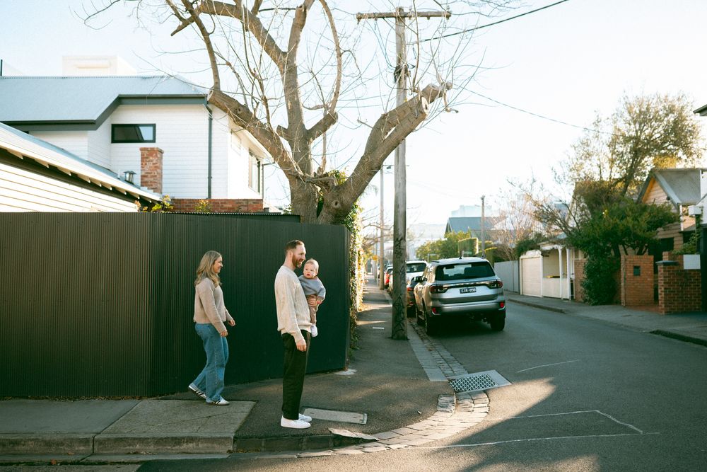 Multiple connected photos of people walking and posing on a residential street with bare trees in winter.