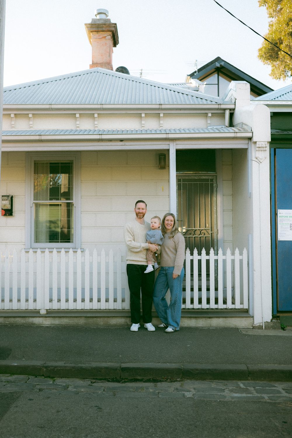 A series of four connected photos showing people standing in front of a white cottage house with a picket fence.