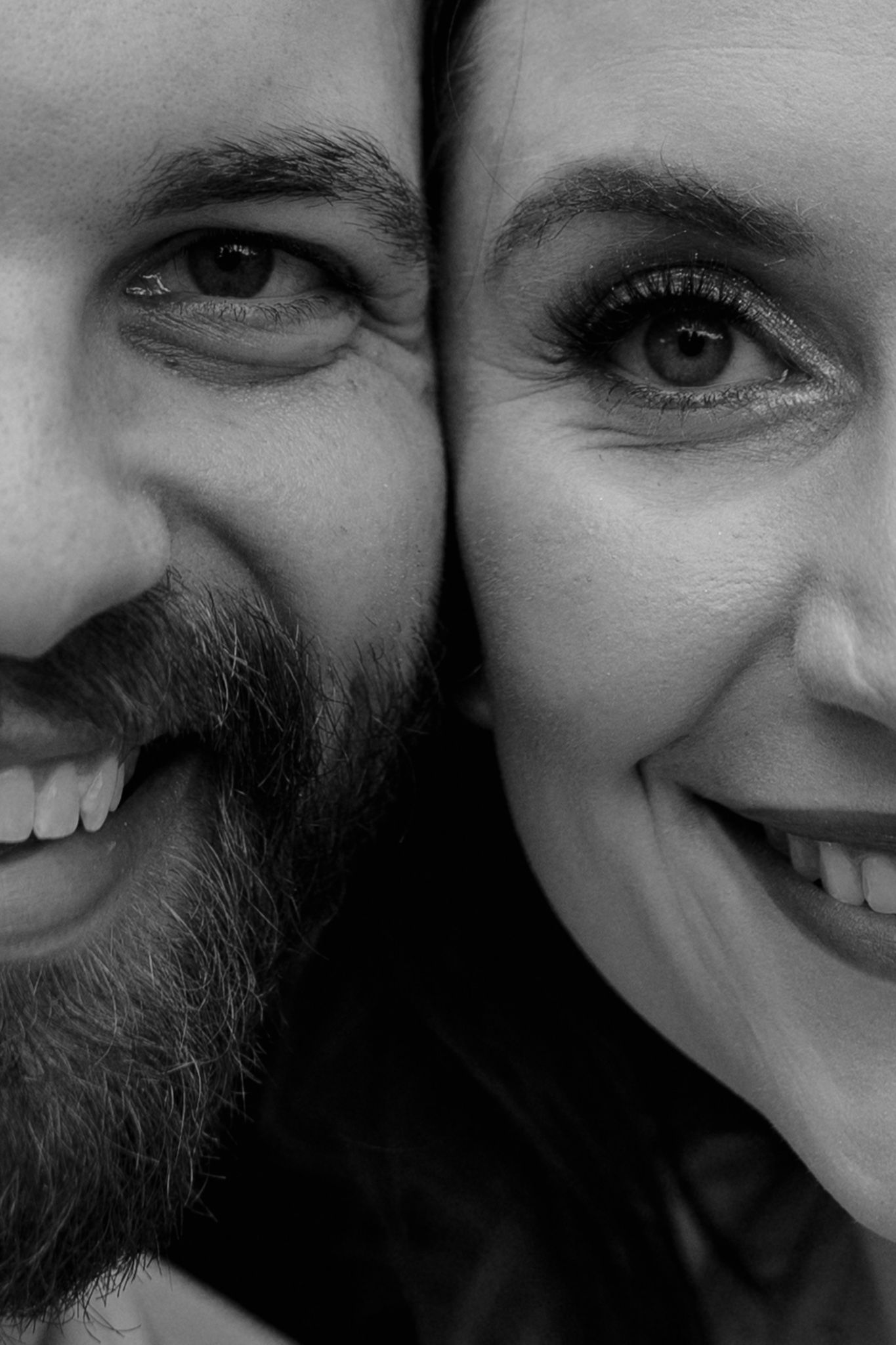 Artistic black and white close-up portrait showing eyes and smiles.