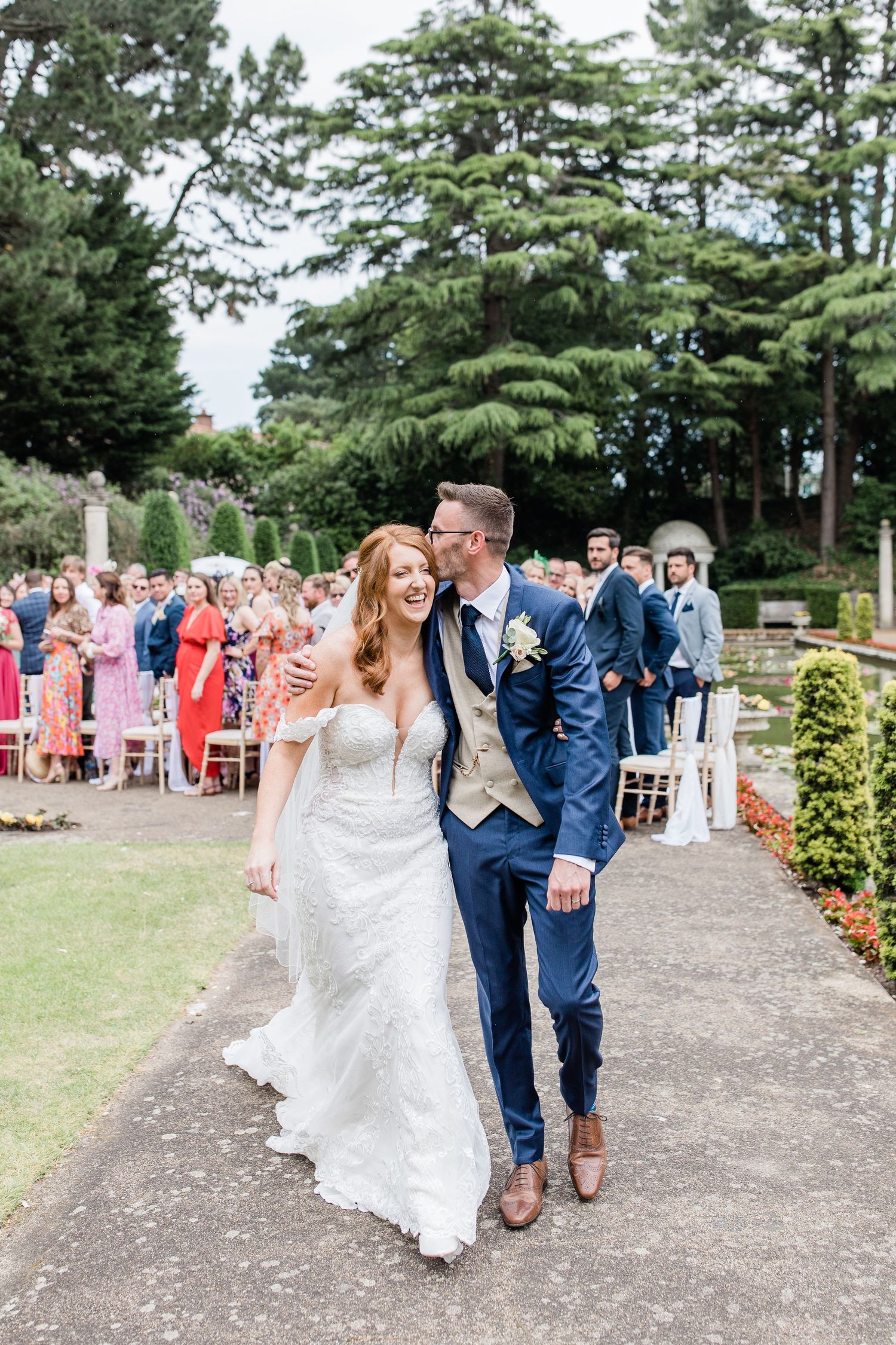 Romantic wedding couple embraces in a lush garden setting with manicured hedges at The Italian Villa photographed by Maddie Waters