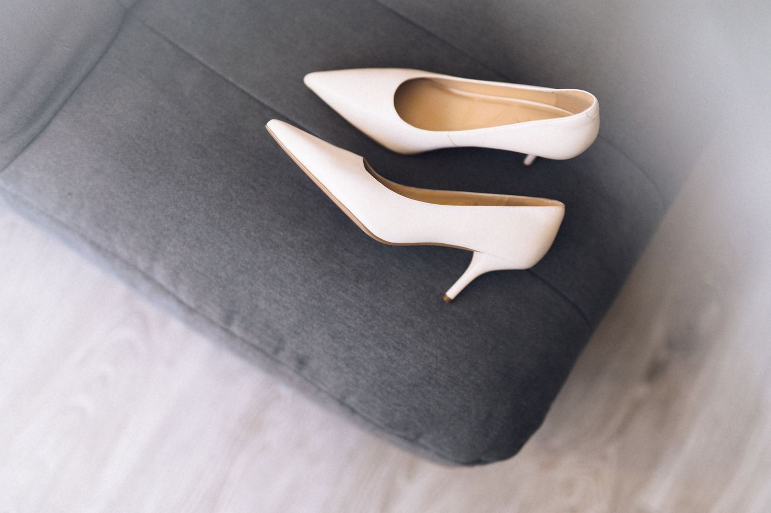 Close-up view of elegant white and black women's high heel shoes arranged in a row on a gray surface.