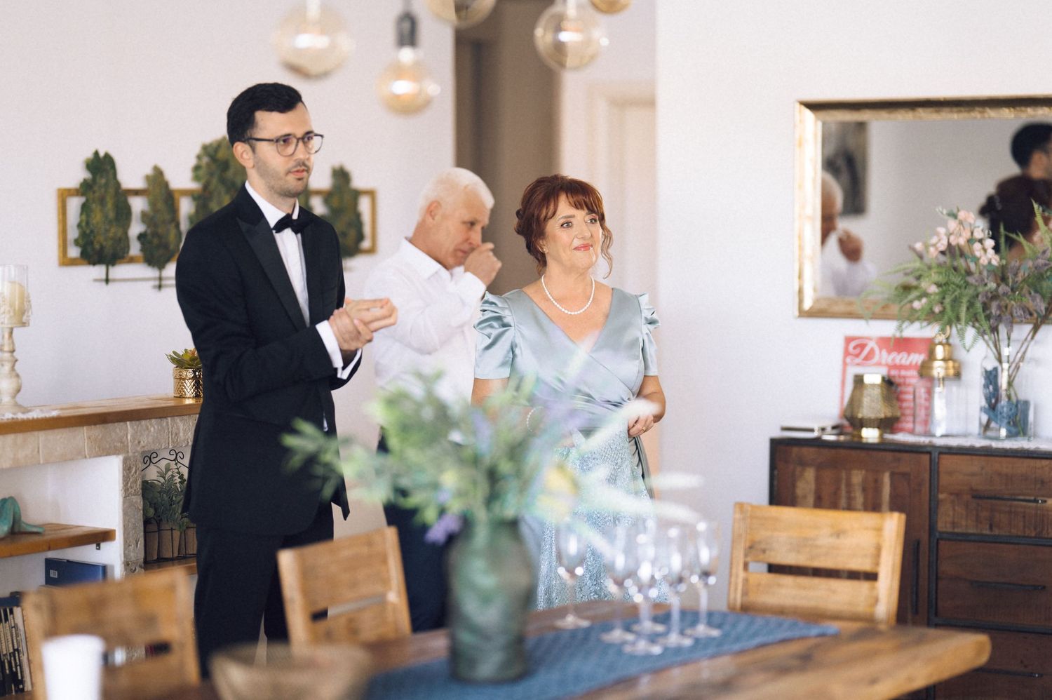 Wedding guests in formal attire mingle and socialize during an elegant indoor reception.