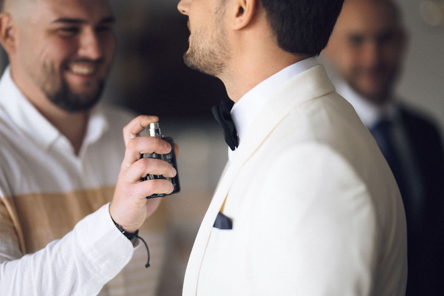 A series of candid moments showing someone spraying cologne or perfume while getting dressed in formal attire.