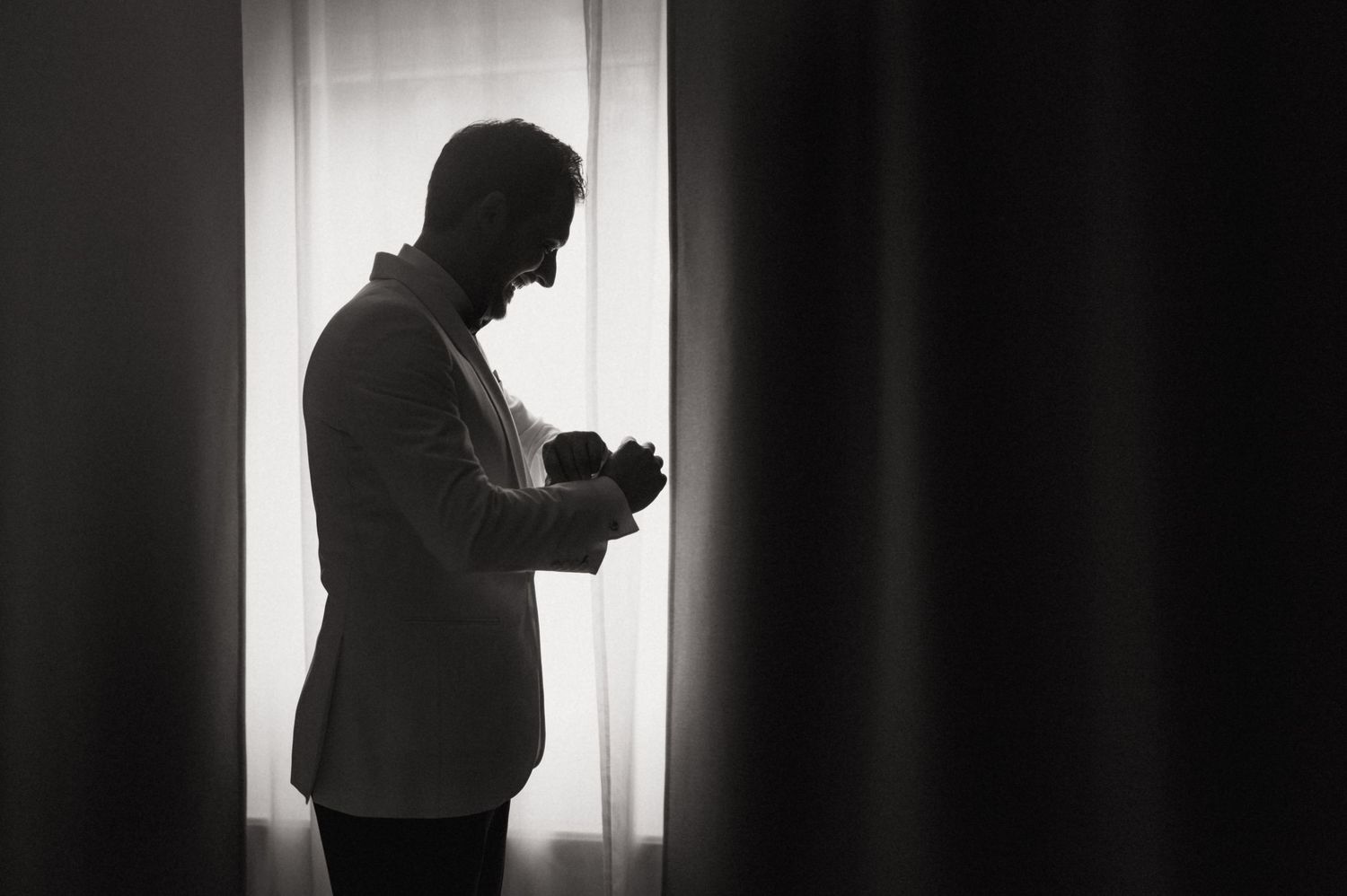 Four black and white silhouettes of a person using a mobile phone against a bright window background.