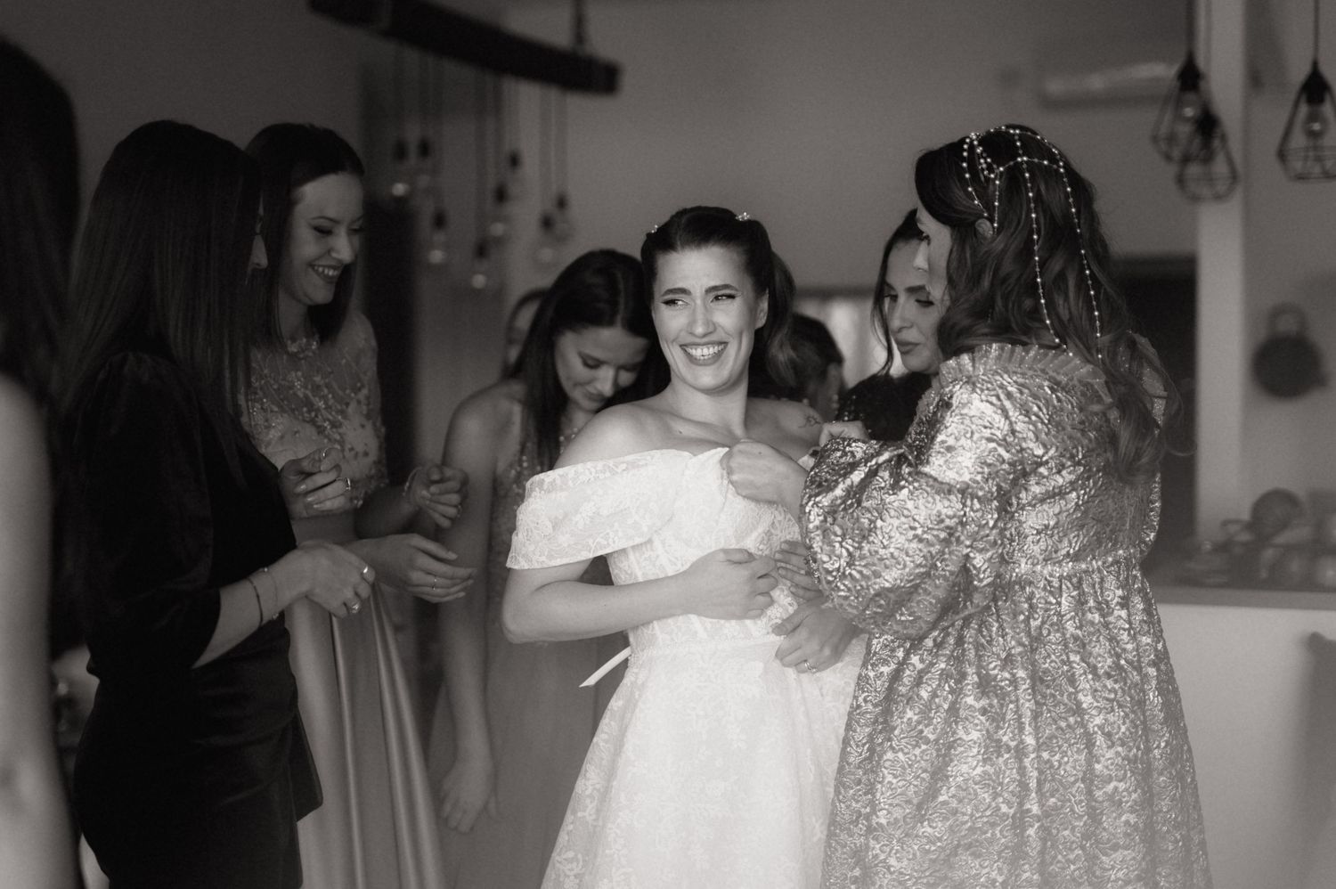 Wedding guests dance and celebrate together on a dance floor at an indoor reception venue.
