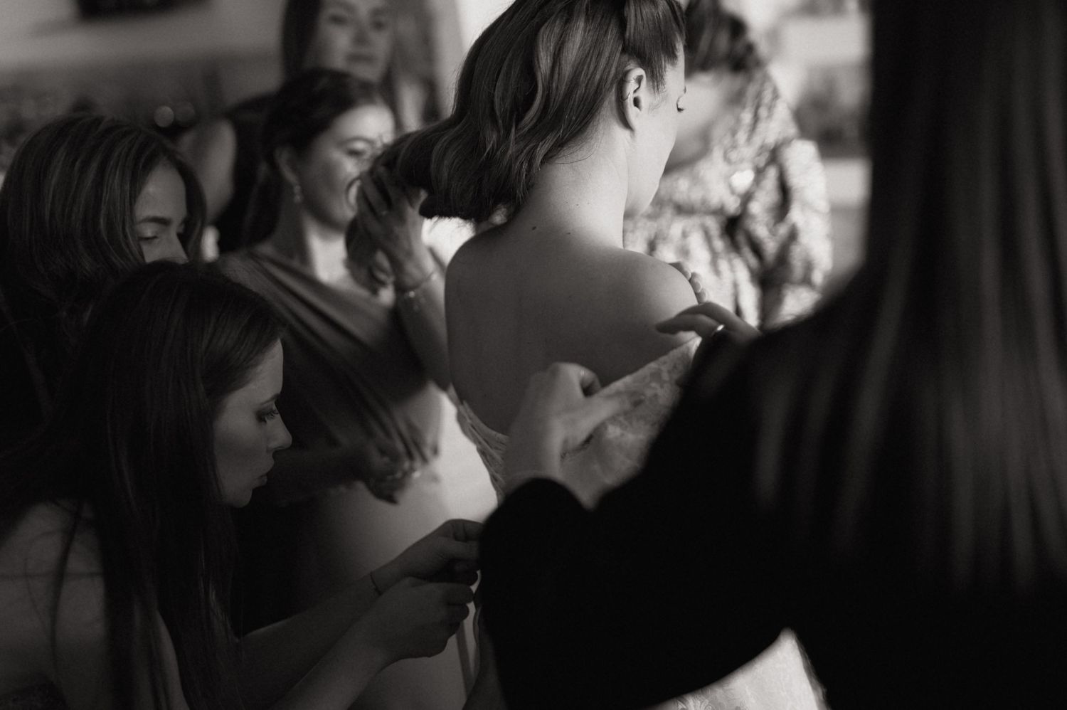 A series of black and white wedding photos showing intimate moments between couples during their celebration.