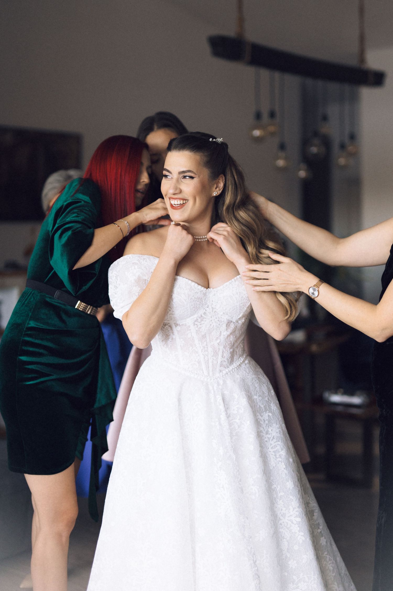A series of candid moments showing a bride in a white lace dress sharing joyful embraces during a wedding celebration.