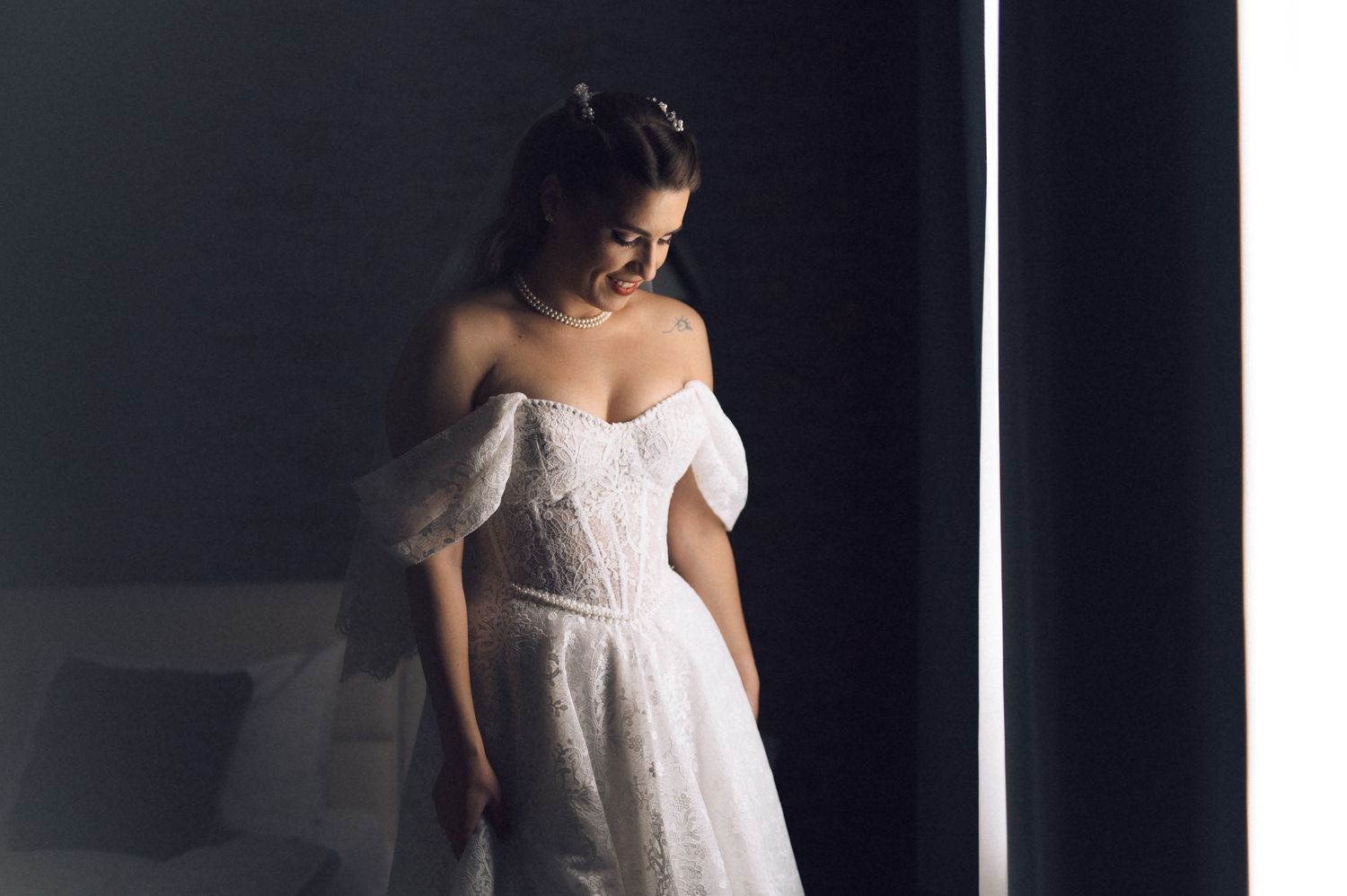 A bride in a flowing white wedding dress stands elegantly against a dark background in a series of artistic poses.