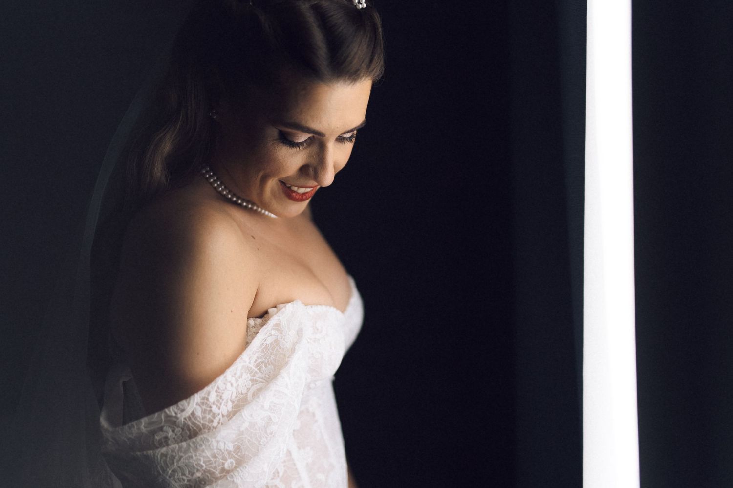 A series of five romantic boudoir photos showing a woman in a white lace gown against a dark background.