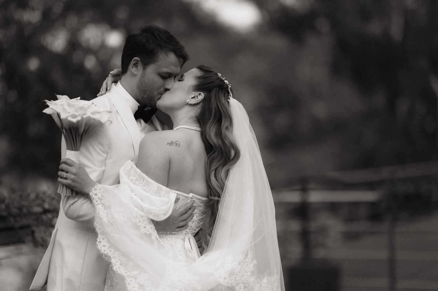 A series of black and white wedding photos showing intimate moments between a couple in formal attire.