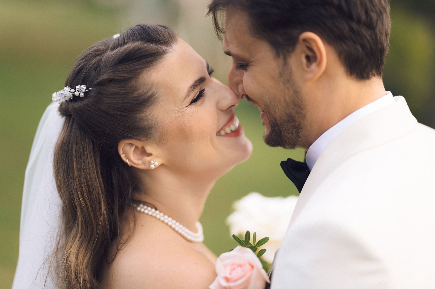 A bride and groom share an intimate moment outdoors during their wedding photo session.