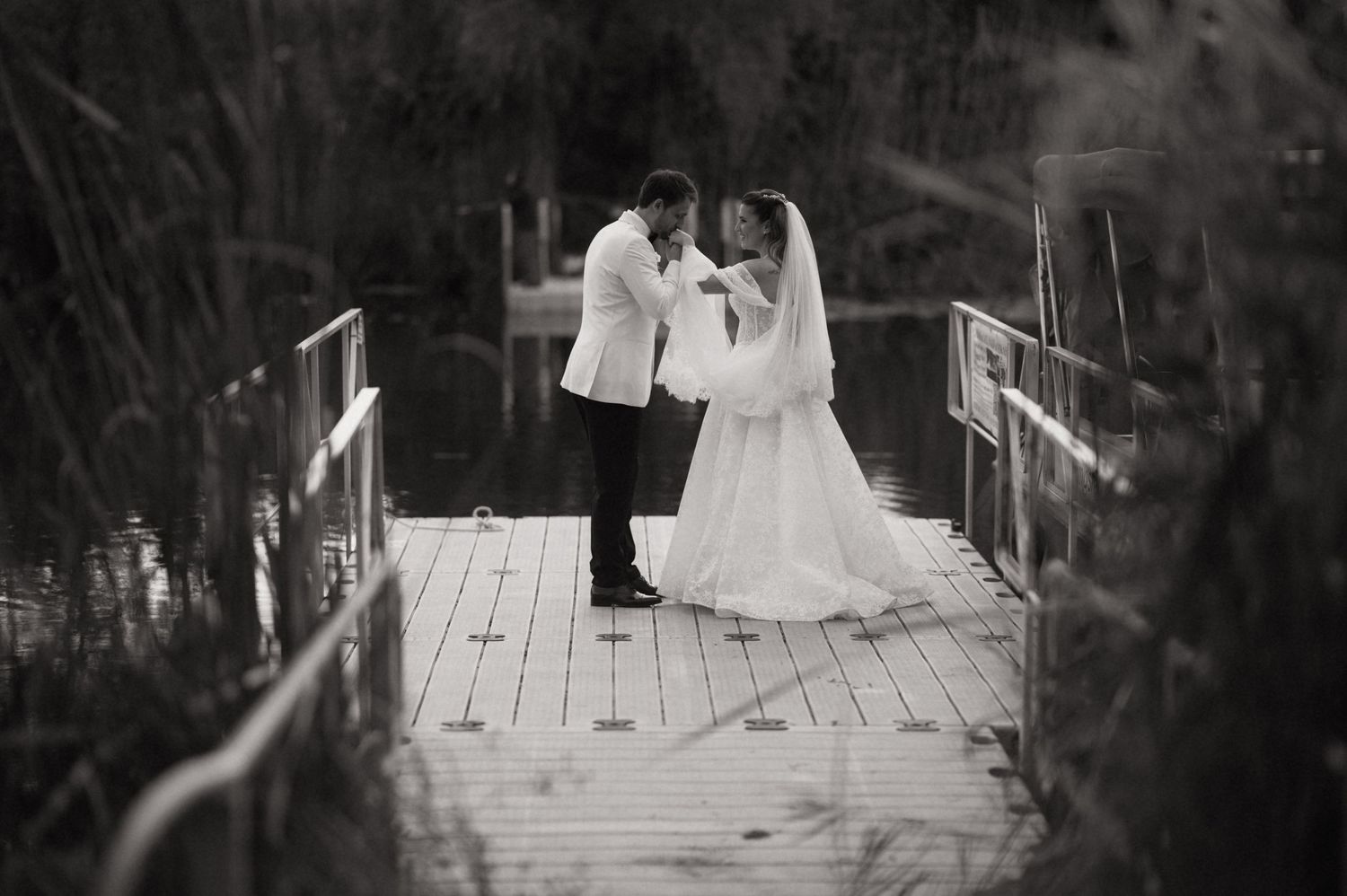 A black and white wedding photo montage showing six romantic moments between a couple in formal attire outdoors.