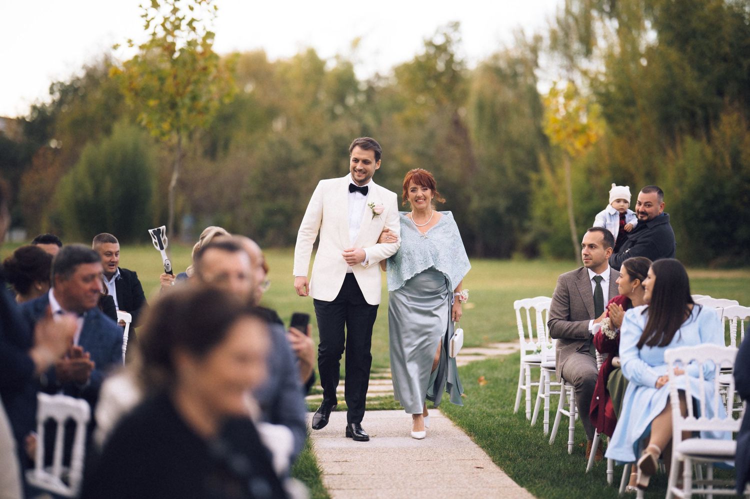 A collection of outdoor wedding ceremony photos showing guests and decorations in a natural setting at sunset.