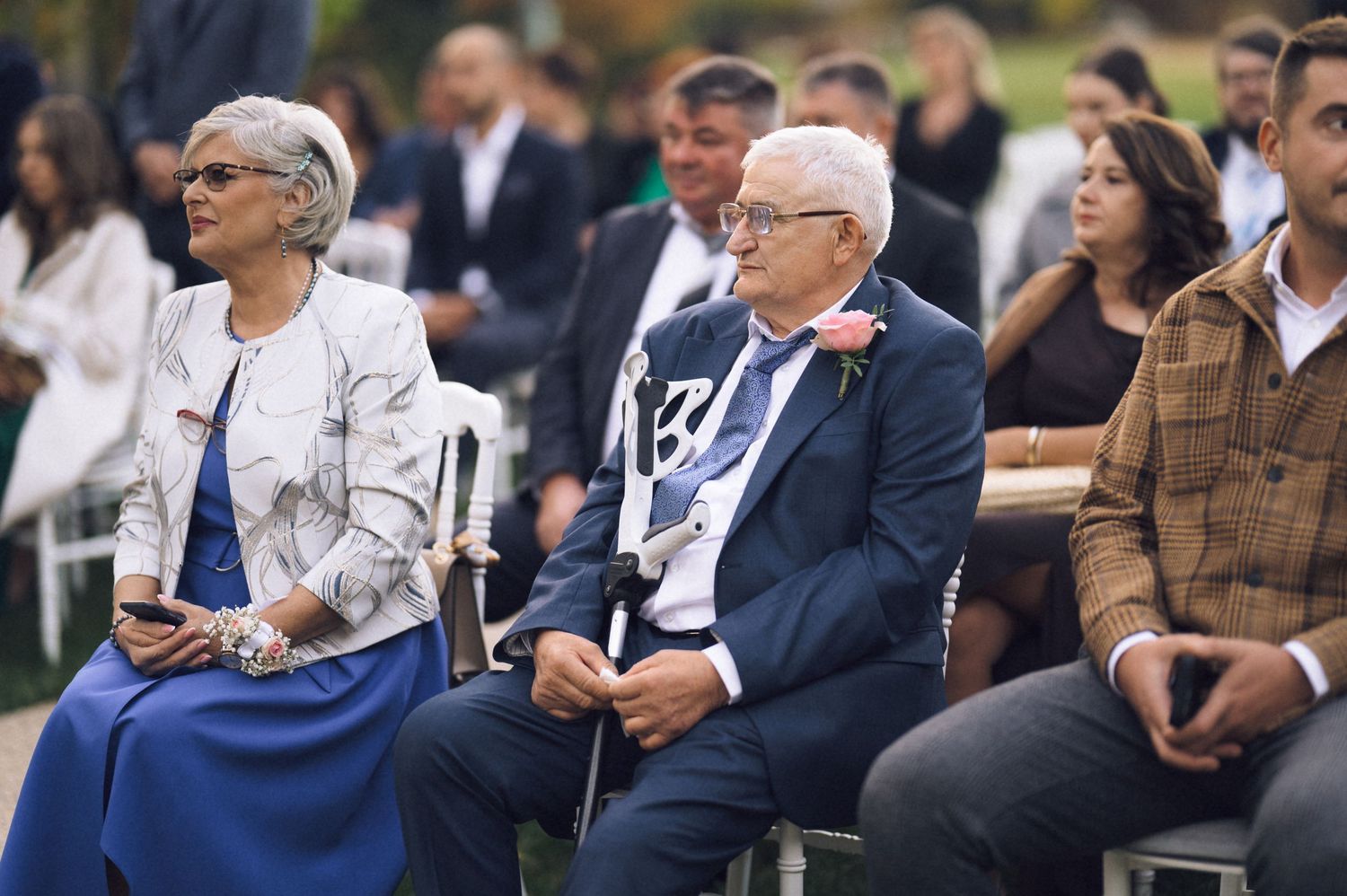 A row of spectators sitting and watching intently during a formal event or gathering.