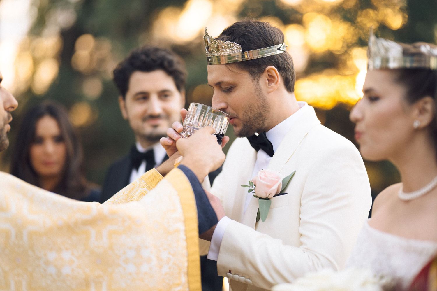Wedding party enjoying outdoor celebration during golden hour with warm sunset lighting.