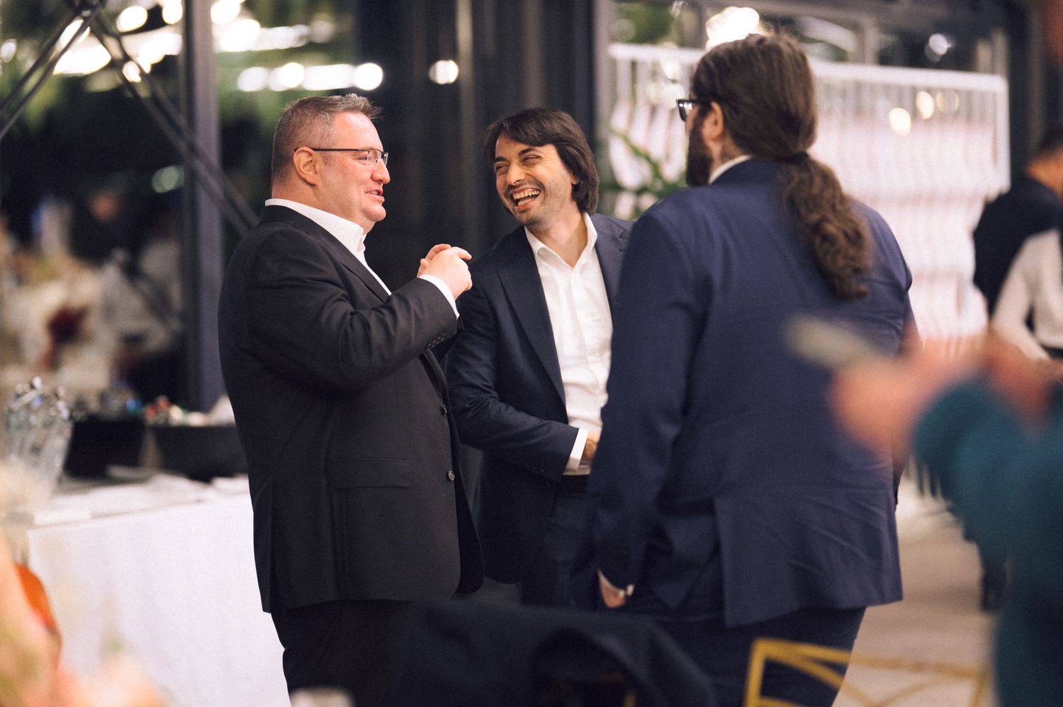 Business professionals engage in conversation at a networking event in a modern office setting.